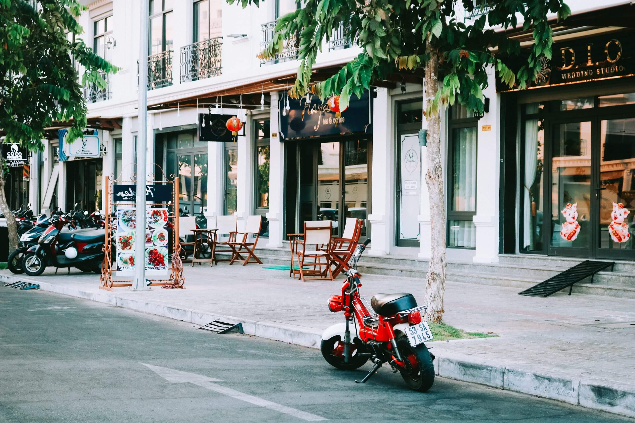 Een rode scooter in Vietnam, geparkeerd in een lege straat